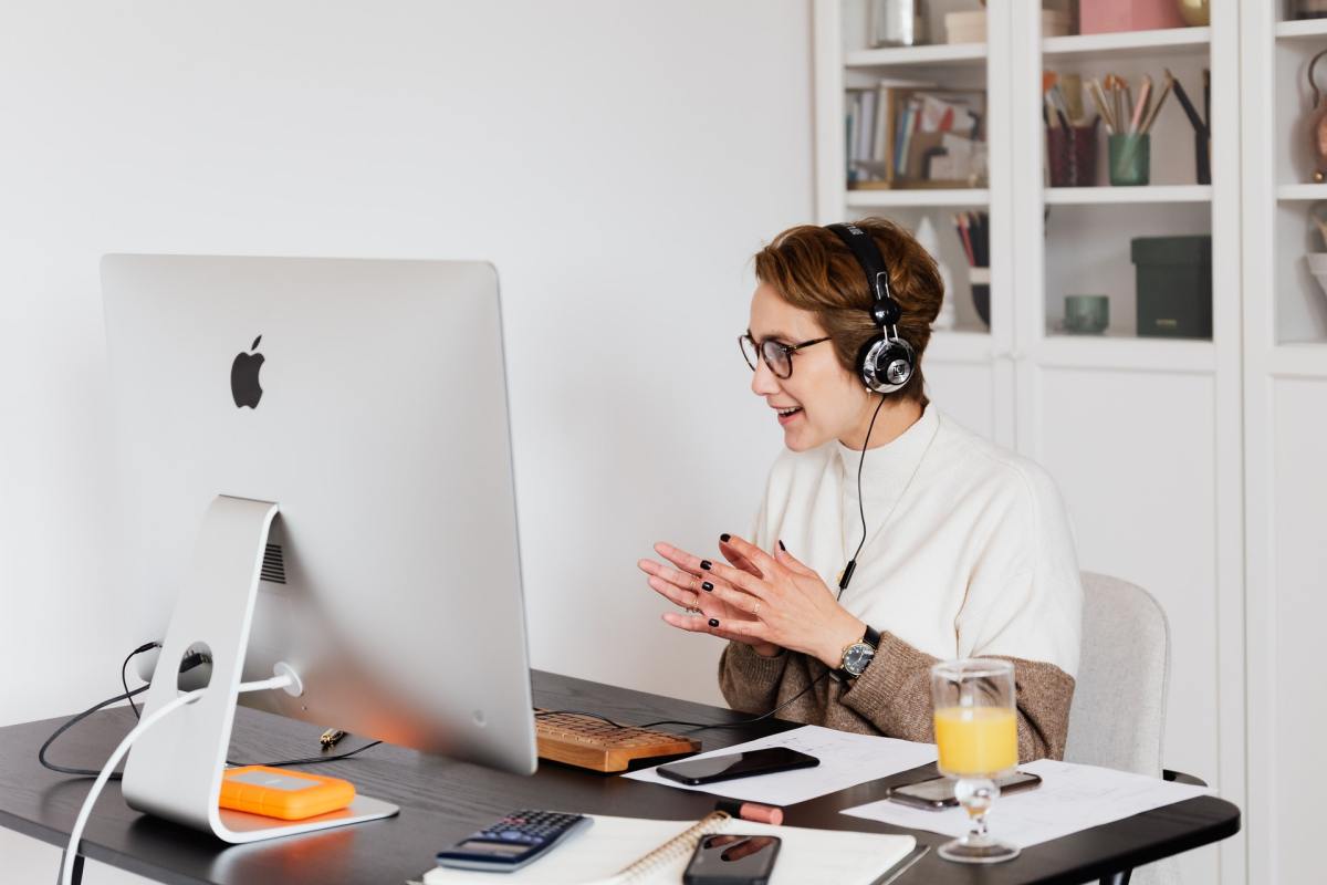 Woman speaking to someone from desktop computer